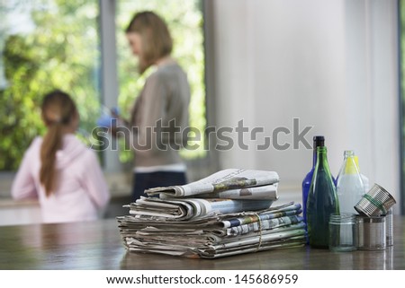 Recycling material on kitchen table with family in background