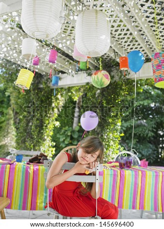 Young little girl sleeping at table after birthday party