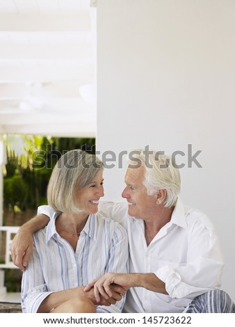 Happy middle aged couple sitting on verandah
