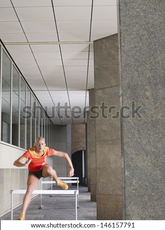 Full length of a young woman jumping hurdles in portico