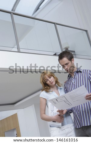 Low angle view of a young couple observing plan in new home