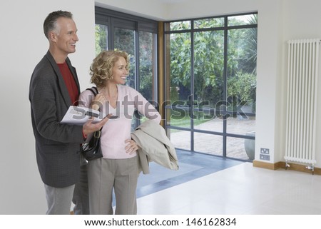 Happy couple with brochure observing new property