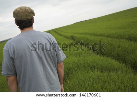 Rear view of a man standing in tilt field