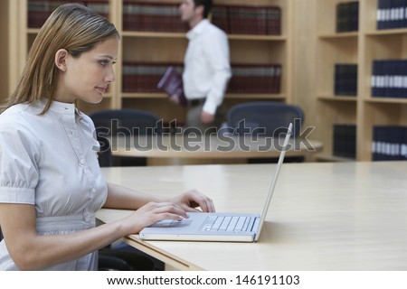 Side view of a female office worker using laptop in legal office