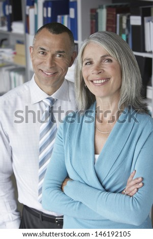 Portrait of a smiling middle aged business couple in office