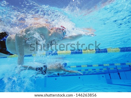 Underwater shot of three male athletes in swimming competition