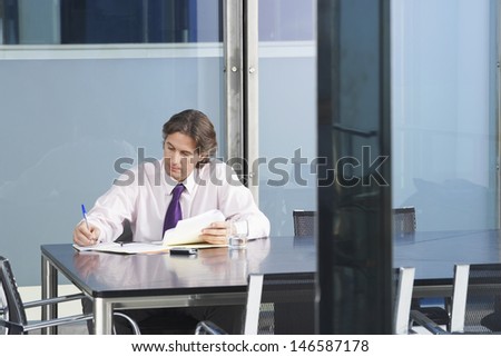 Young businessman with paperwork at conference table