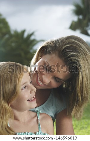 Closeup of a happy mother and daughter talking outdoors