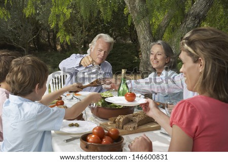 Three generation family dining in the garden