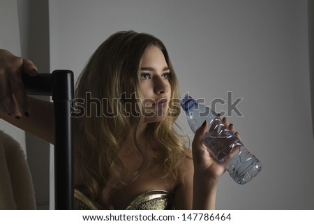 Female fashion model drinking water during photo shoot
