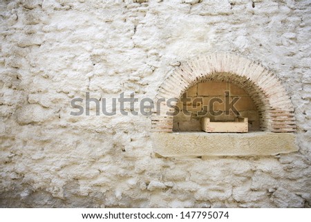 Extreme closeup of a white painted wall with arch shaped shelf