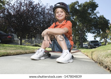 Similar – Foto Bild Kinderskateboardfahrer, der auf seinem Skateboard sitzt.