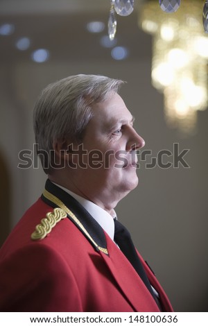 Closeup side view of thoughtful middle aged porter in red jacket
