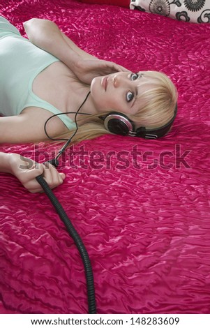Teenage girl listening to music while lying in bed