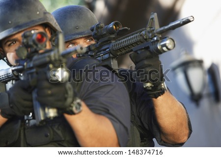 Closeup of police officers aiming with guns