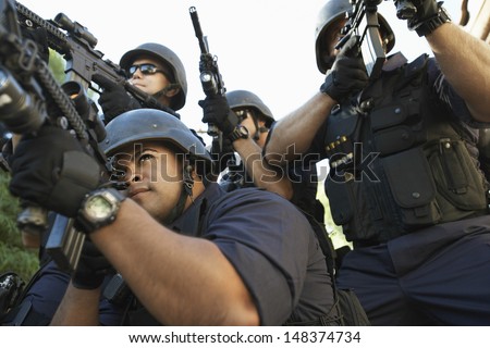 Group of police officers aiming with guns