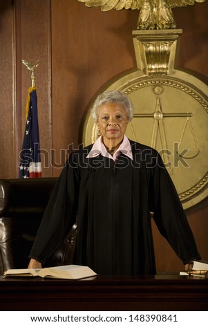 Portrait of confident senior female judge standing in court room