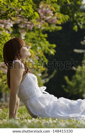 Side view of beautiful young woman relaxing in park