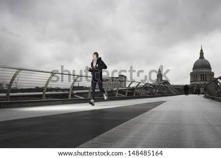 Full length of a young male runner with St Paul\'s in the background