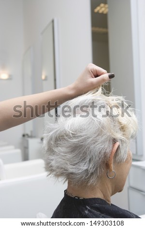 Closeup side view of senior woman getting her hair done in salon