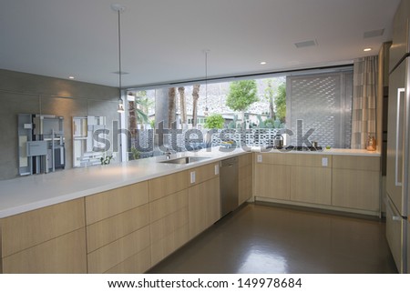 Open plan kitchen furnished in light wood at home