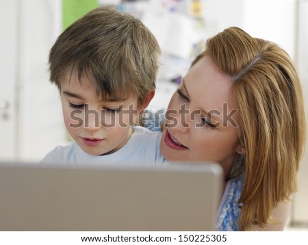 Young woman and son using laptop at home