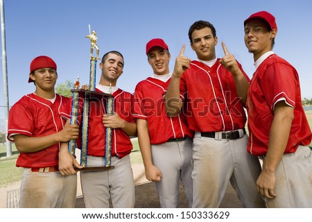 Portrait of successful baseball team with trophy on field