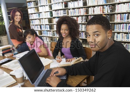 Group of multiethnic college students studying together in library