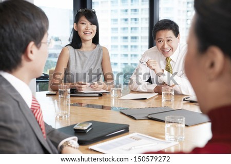 Young Asian business people having discussion in boardroom