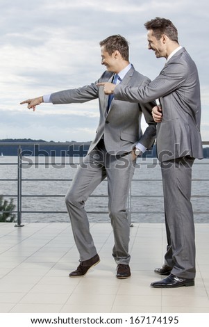 Businessmen pointing at something against sky