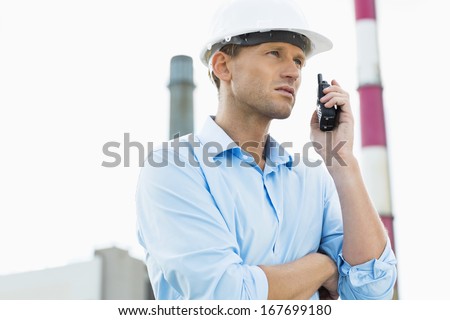 Male architect communicating on two way radio at site