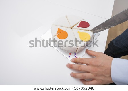 Cropped image of man cutting birthday cake at table