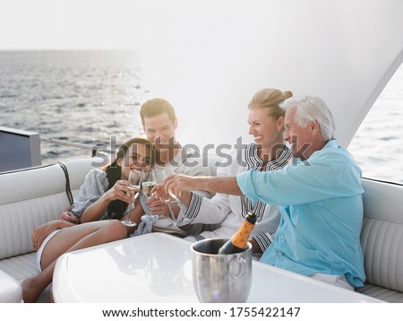 Two generational family celebrating with champagne on yacht