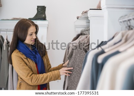 Woman selecting sweater in store