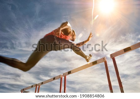 Runner jumping over running hurdle, low angle view Сток-фото © 