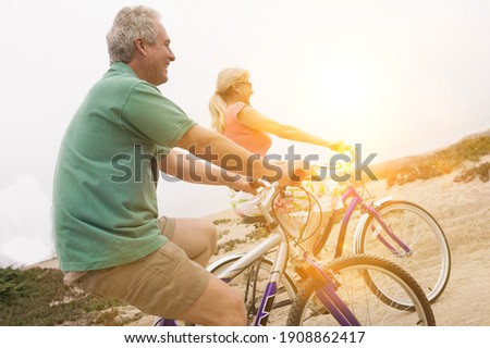 Middle aged couple riding bicycles with lens flare 商業照片 © 