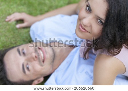 High angle portrait of playful young woman on top of man in park
