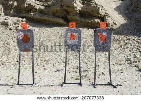 Three targets with bullet holes at firing range