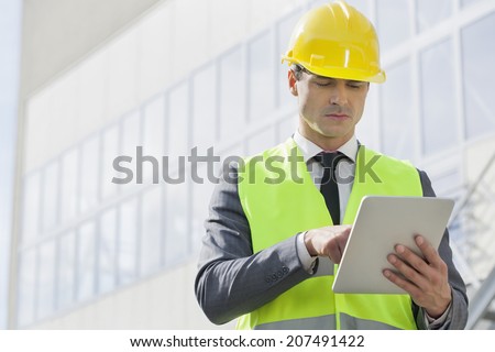 Young male engineer using digital tablet outside industry
