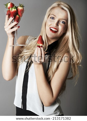 Pretty blonde girl holding glass of Strawberries