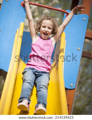 Close-up view of young girl on slide in playground