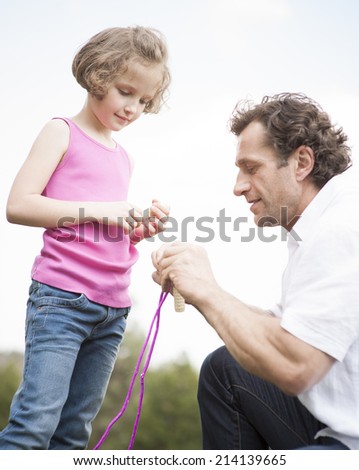 Father and daughter together with skipping rope
