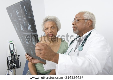 Senior practitioner  and patient examine xray