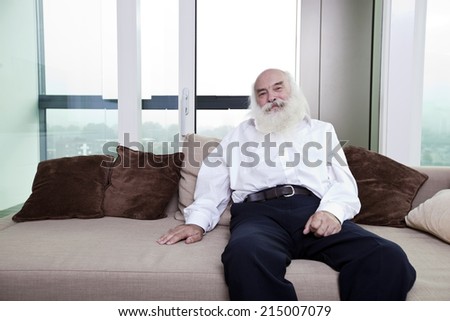Portrait of senior man relaxing on sofa in apartment