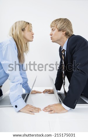 Side view of business couple kissing in office