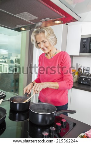 Smiling senior woman preparing food at kitchen counter