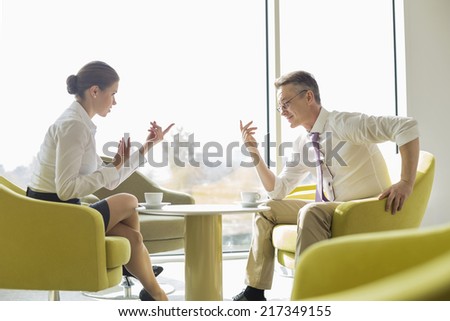 Side view of business people conversing at lobby