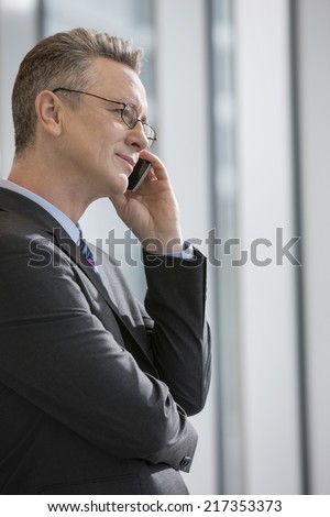 Side view of businessman using cell phone in office