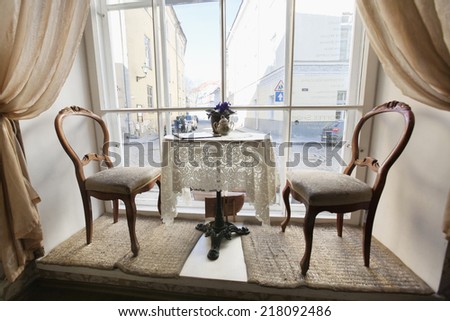Table and chairs by window in empty cafe