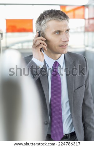 Middle aged businessman using cell phone at train station